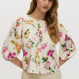 Cream floral linen blouse with puff sleeves and button-front closure.