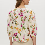 Cream floral linen blend blouse featuring puff sleeves and button-front closure by Hilary Radley.