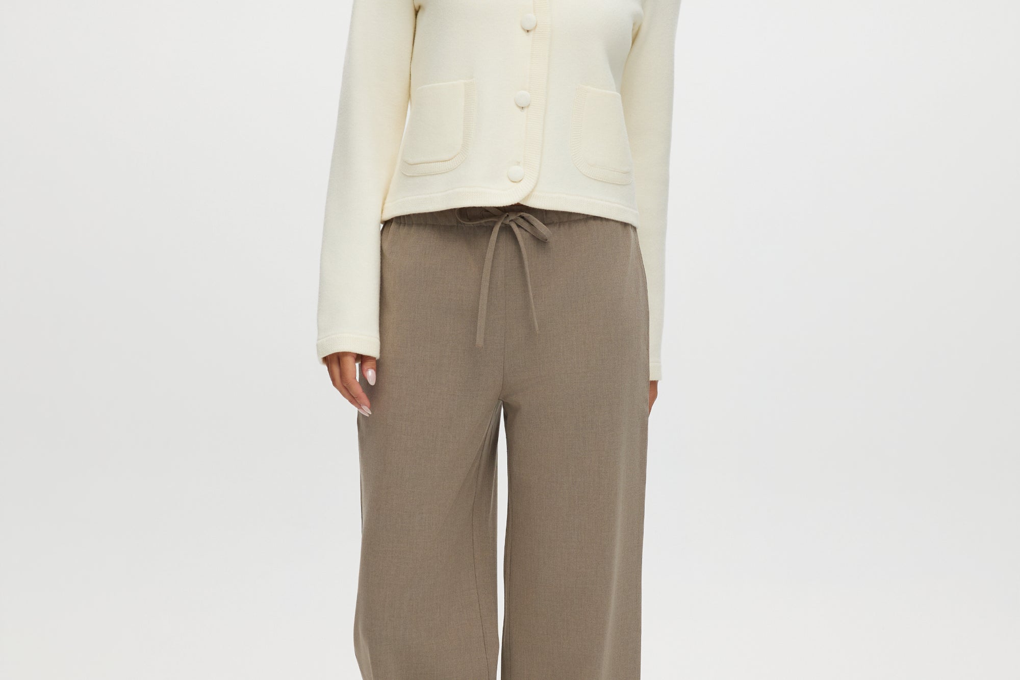 Cream knit cardigan with round collar and patch pockets by Hilary Radley.