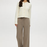 Cream knit cardigan with round collar and patch pockets by Hilary Radley.