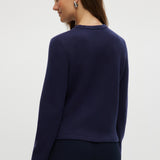 Navy knit cardigan featuring a round collar, long sleeves, and front pockets by Hilary Radley.