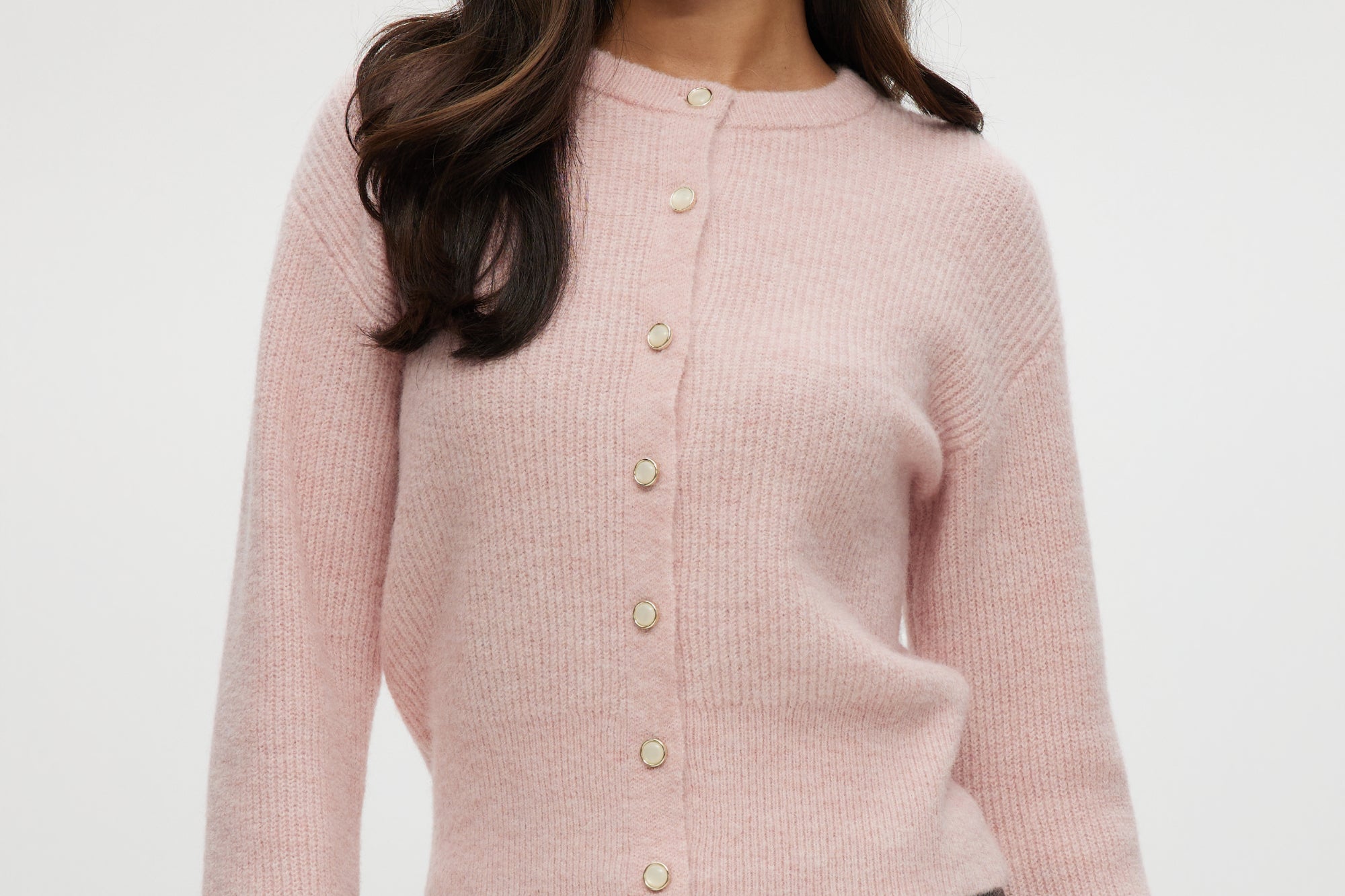 Pink shaker stitch cardigan with crew neck and button-front closure.