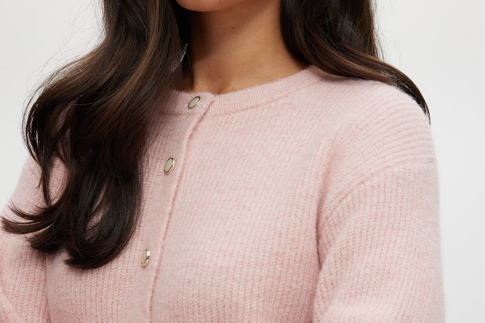 Pink Shaker Stitch Crew Neck Cardigan featuring a button-front closure, sold by Hilary Radley.