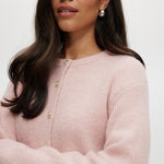 Pink Shaker Stitch Crew Neck Cardigan featuring a button-front closure, sold by Hilary Radley.