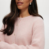 Pink Shaker Stitch Crew Neck Cardigan featuring a button-front closure, sold by Hilary Radley.