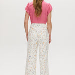 White high-rise straight leg pants with a floral print, button-front closure, and pockets by Hilary Radley.