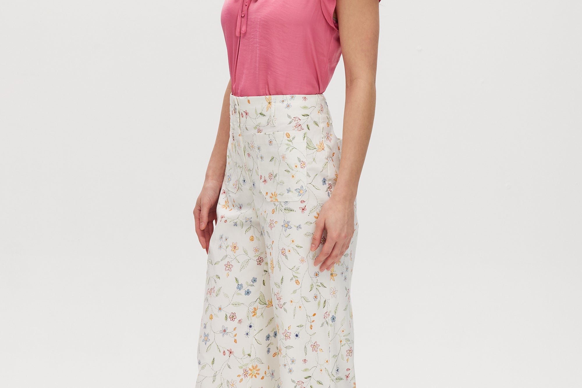 White High-Rise Floral Straight Leg Pants with button-front closure and pockets, sold by Hilary Radley.