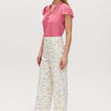White High-Rise Floral Straight Leg Pants with button-front closure and pockets, sold by Hilary Radley.
