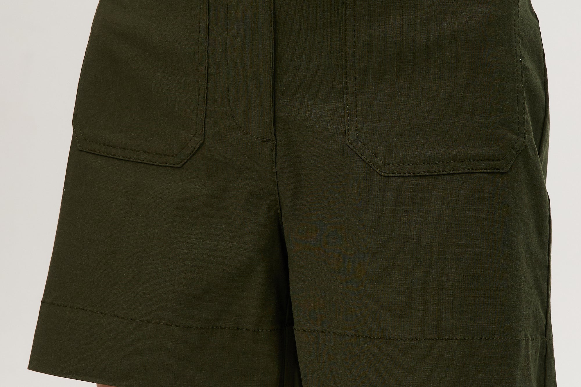 Olive high-rise stretch shorts featuring a button closure, front patch pockets, and textured fabric by Hilary Radley.