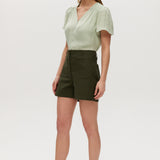 Olive high-rise stretch shorts featuring button closure, front patch pockets, and textured fabric by Hilary Radley.