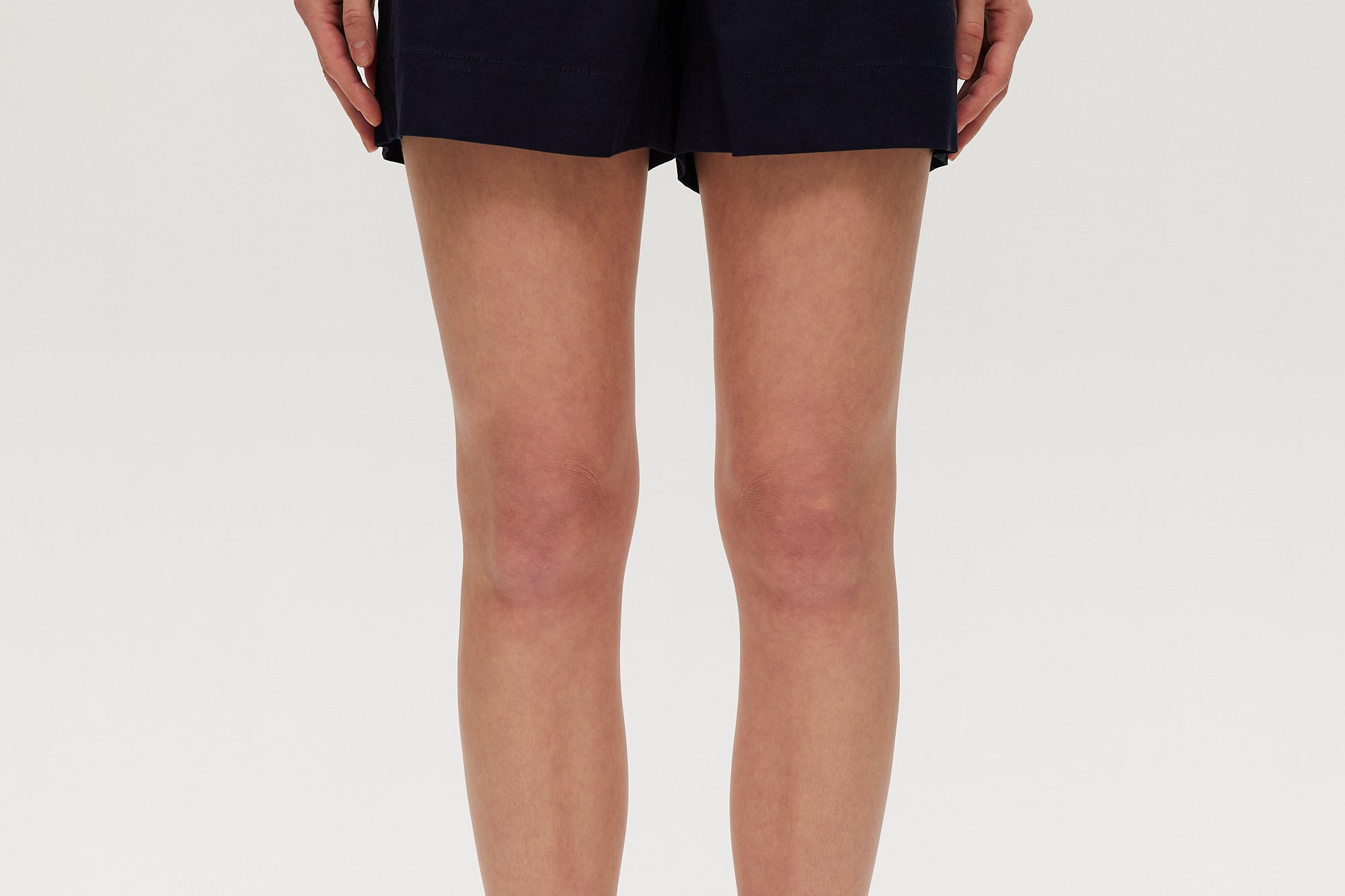 Navy high-rise stretch shorts featuring a structured waistband and functional pockets by Hilary Radley.