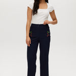 Navy high-rise straight leg pants with embroidery and front patch pockets.