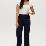 Navy high-rise straight leg pants with embroidery and front patch pockets.