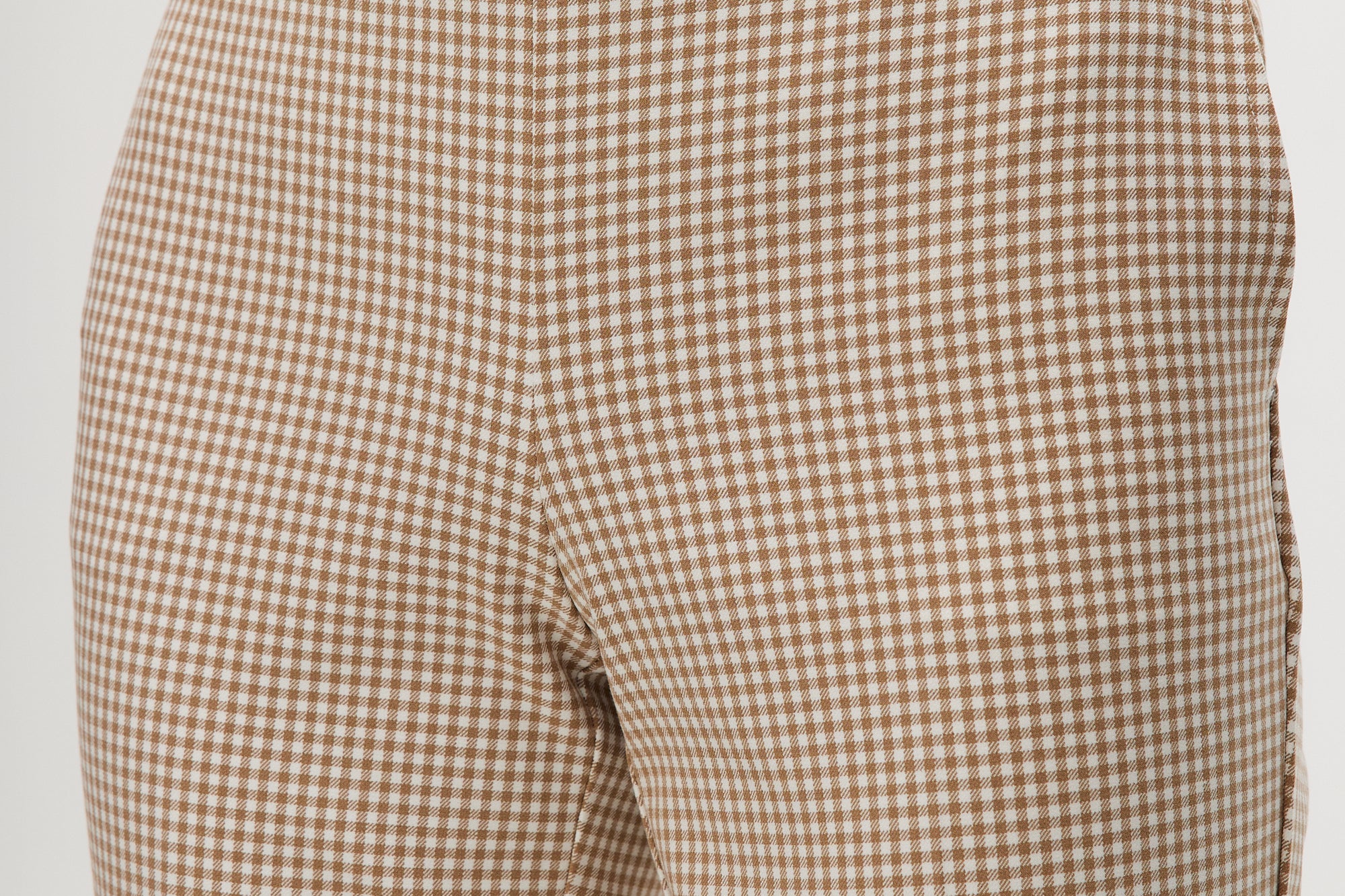 Beige checked slim leg pants featuring a button-front and pockets by Hilary Radley.