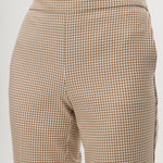 Beige checked slim leg pants featuring a button-front and pockets by Hilary Radley.