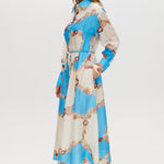 Azure Floral Printed Linen Blend Maxi Dress featuring a classic collar, long sleeves, button-front design, and adjustable waist by Hilary Radley.