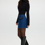 Blue denim mini skirt featuring contrast vegan leather trim and gold buttons by Hilary Radley.