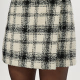 Cream plaid A-line mini skirt featuring a decorative pearl button and boucle texture by Hilary Radley.