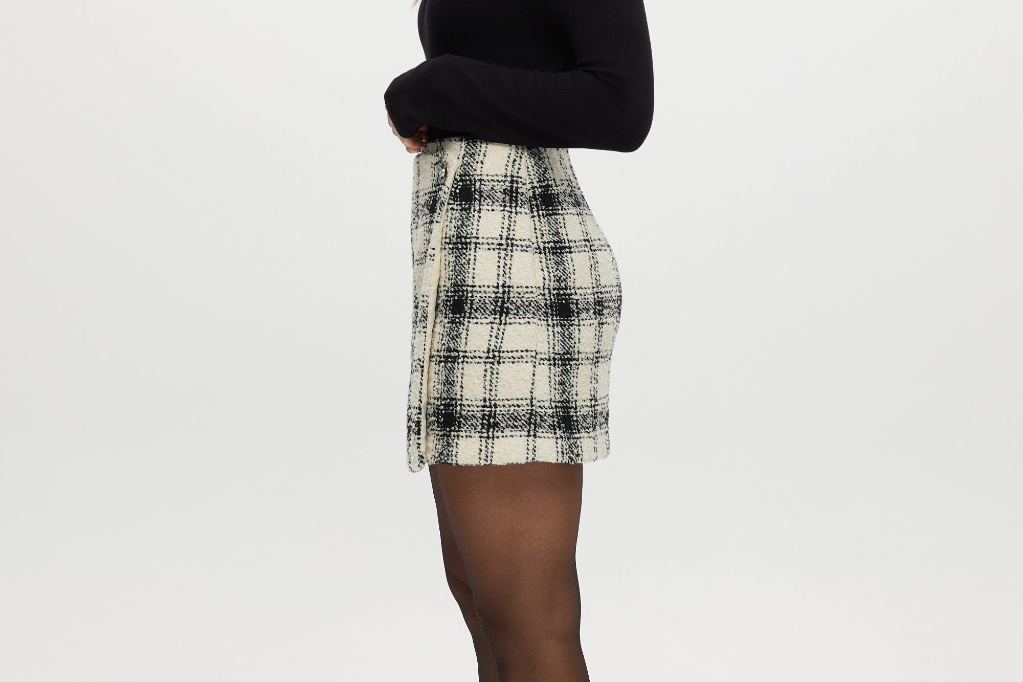 Cream plaid A-line mini skirt featuring decorative pearl button and boucle texture by Hilary Radley.