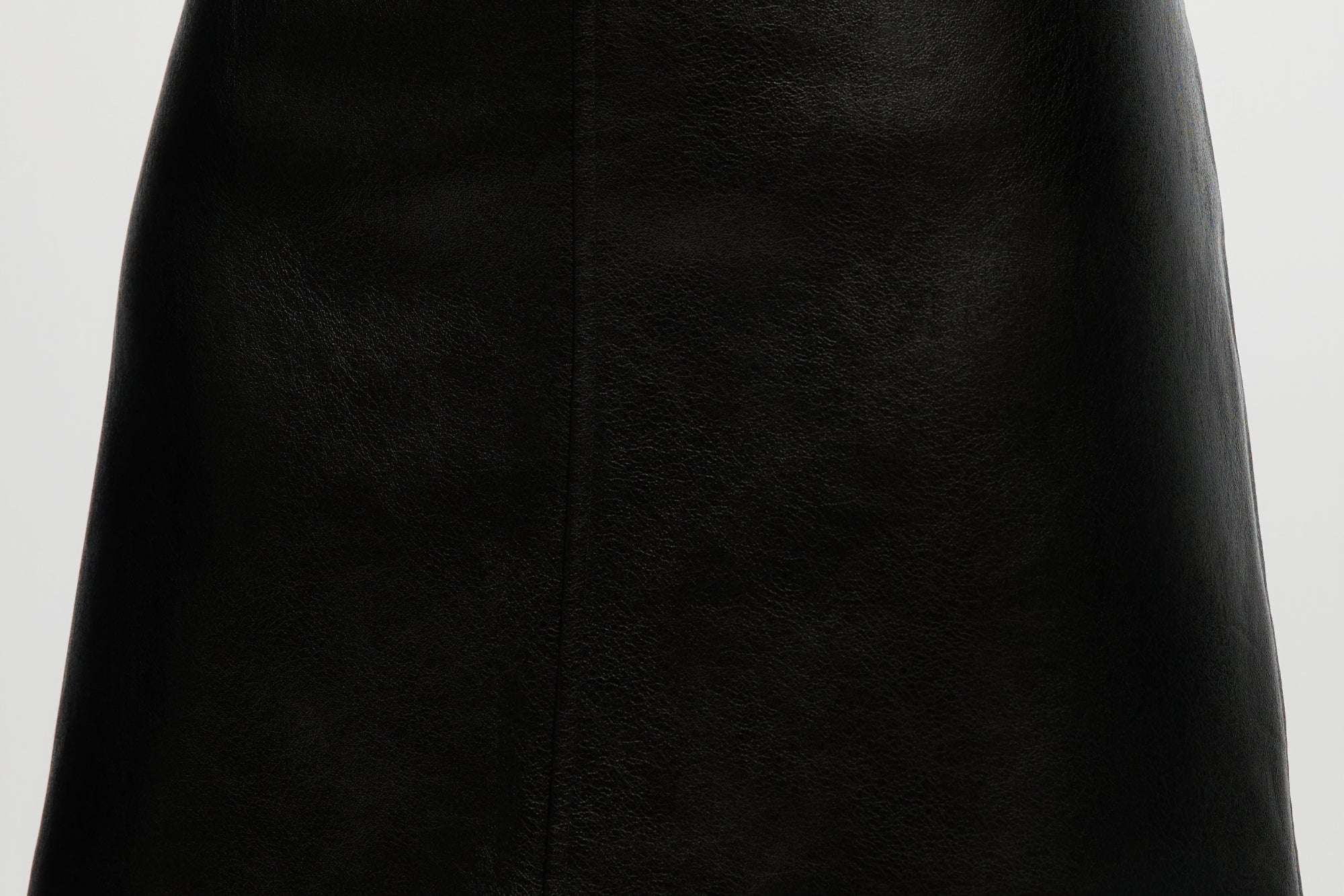 Black vegan leather A-line skirt featuring a high waist and comfort waistband by Hilary Radley.