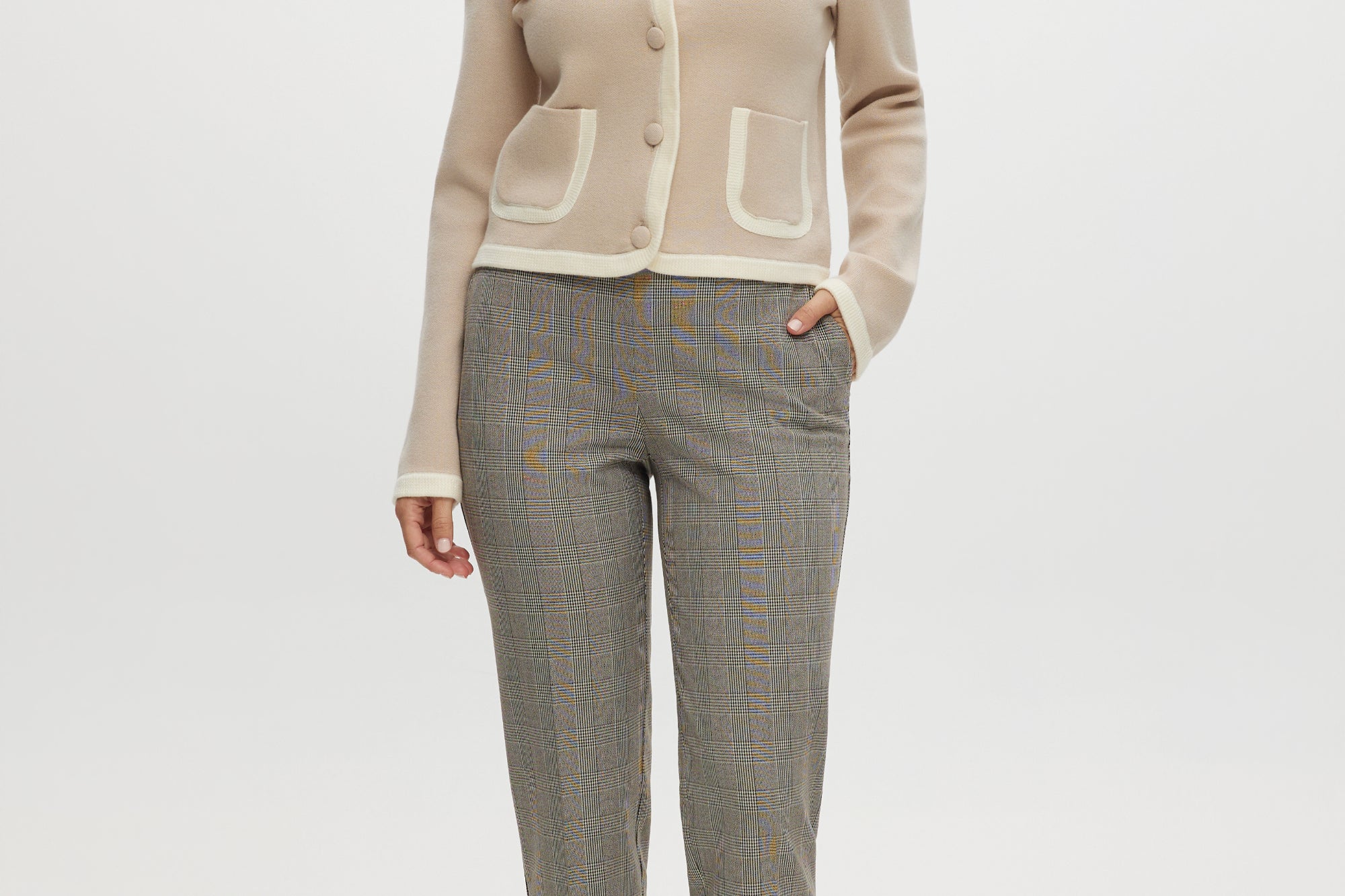 Beige knit cardigan with round collar and contrast trim by Hilary Radley.