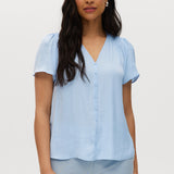 Woman wearing a light blue blouse against a white background