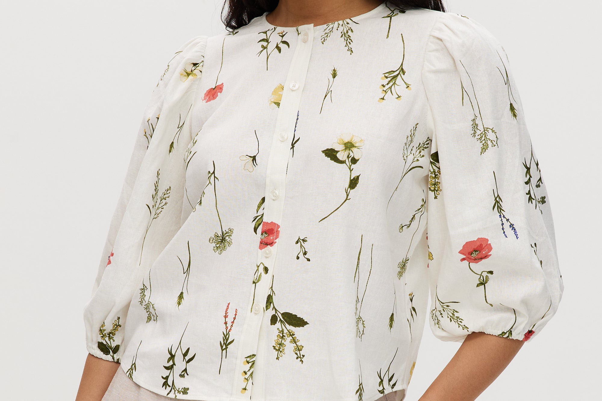 Ivory floral linen blend blouse with 3/4 sleeves and button-front closure.