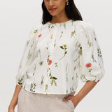 Ivory floral linen blend blouse with 3/4 sleeves and button-front closure.