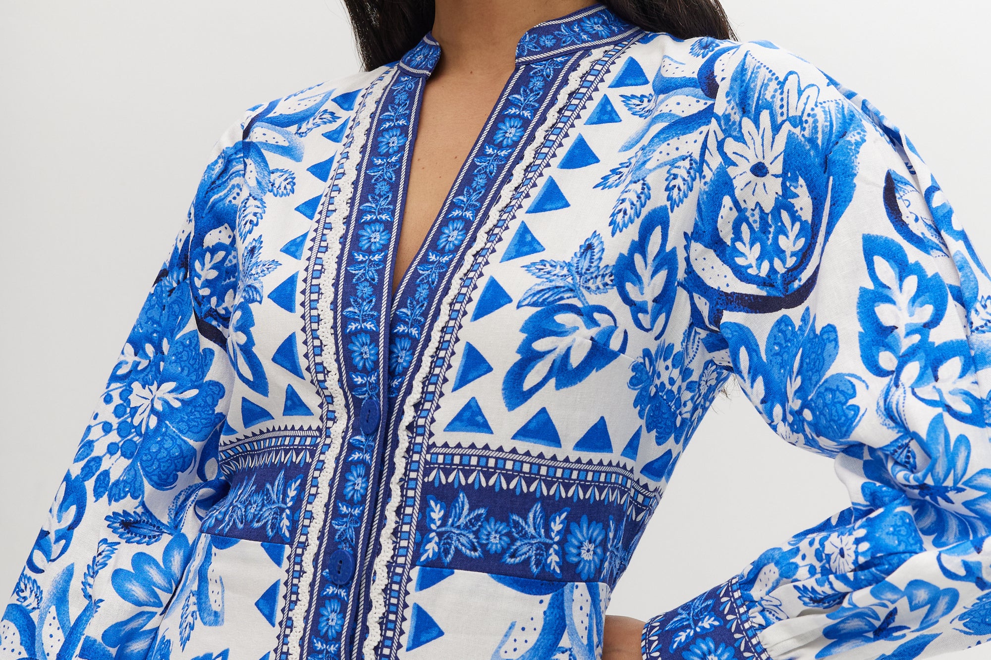 White and Blue Floral Linen Blend Midi Shirt Dress featuring a V-neckline, button front, crochet trim, and puff sleeves by Hilary Radley.