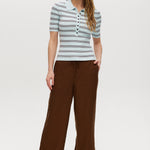 Woman wearing a striped shirt and brown pants on a white background