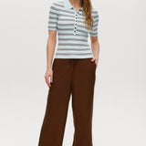 Woman wearing a striped shirt and brown pants on a white background
