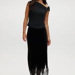 Black asymmetrical one-shoulder top featuring gold detail, available from Hilary Radley.