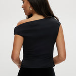 Black asymmetrical one-shoulder top featuring gold detail, available from Hilary Radley.