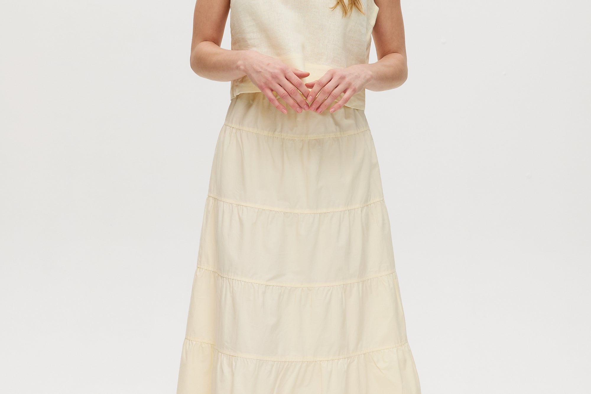 Yellow sleeveless cropped top featuring a crew neckline and tie-back detail by Hilary Radley.