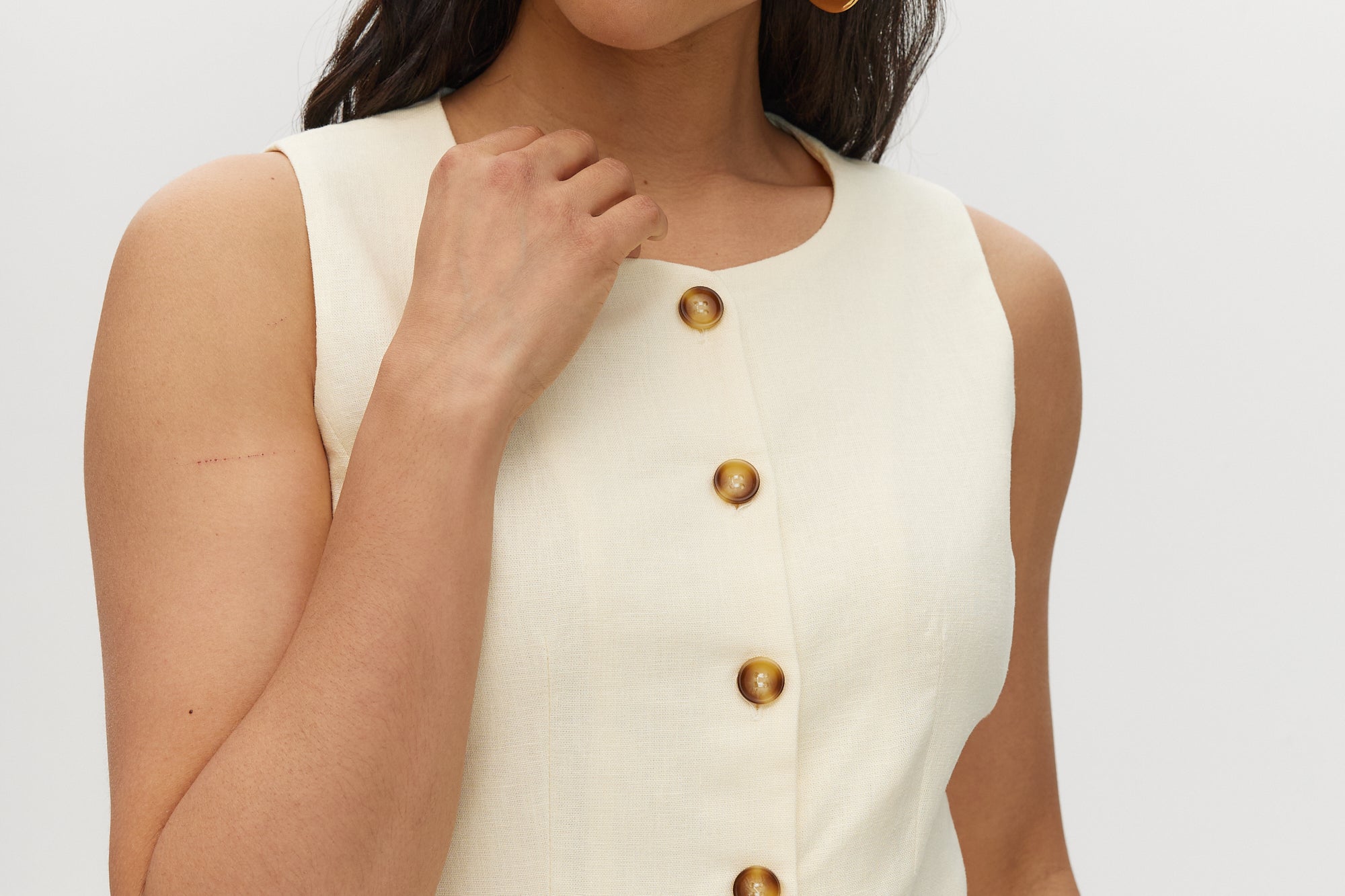 Yellow Button-Front Sleeveless Top in light cream featuring button-front and waist tab detail by Hilary Radley.
