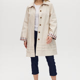 Cream reversible utility jacket with plaid and solid sides, button-front closure, and relaxed fit.