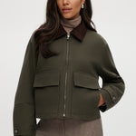 Olive green cotton canvas jacket with contrasting collar, zip-front, and patch pockets.