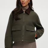Olive green cotton canvas jacket with contrasting collar, zip-front, and patch pockets.