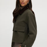 Olive green cotton canvas cropped jacket featuring a contrasting collar, zip-front, and patch pockets by Hilary Radley.