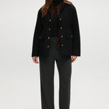 Black utility jacket featuring a brown contrast collar and flap pockets by Hilary Radley.