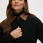 Black utility jacket with a brown contrast collar and flap pockets by Hilary Radley.