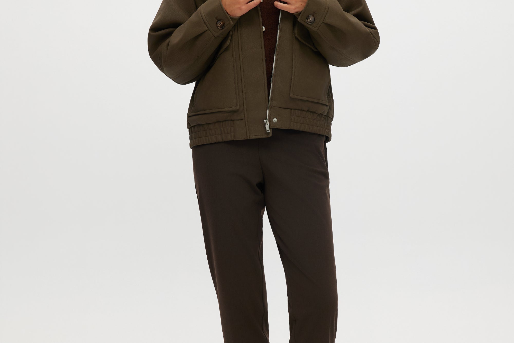 Olive coated jacket featuring a removable faux fur collar, flap pockets, and ribbed hems by Hilary Radley.