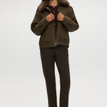 Olive coated jacket featuring a removable faux fur collar, flap pockets, and ribbed hems by Hilary Radley.