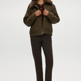 Olive coated jacket featuring a removable faux fur collar, flap pockets, and ribbed hems by Hilary Radley.
