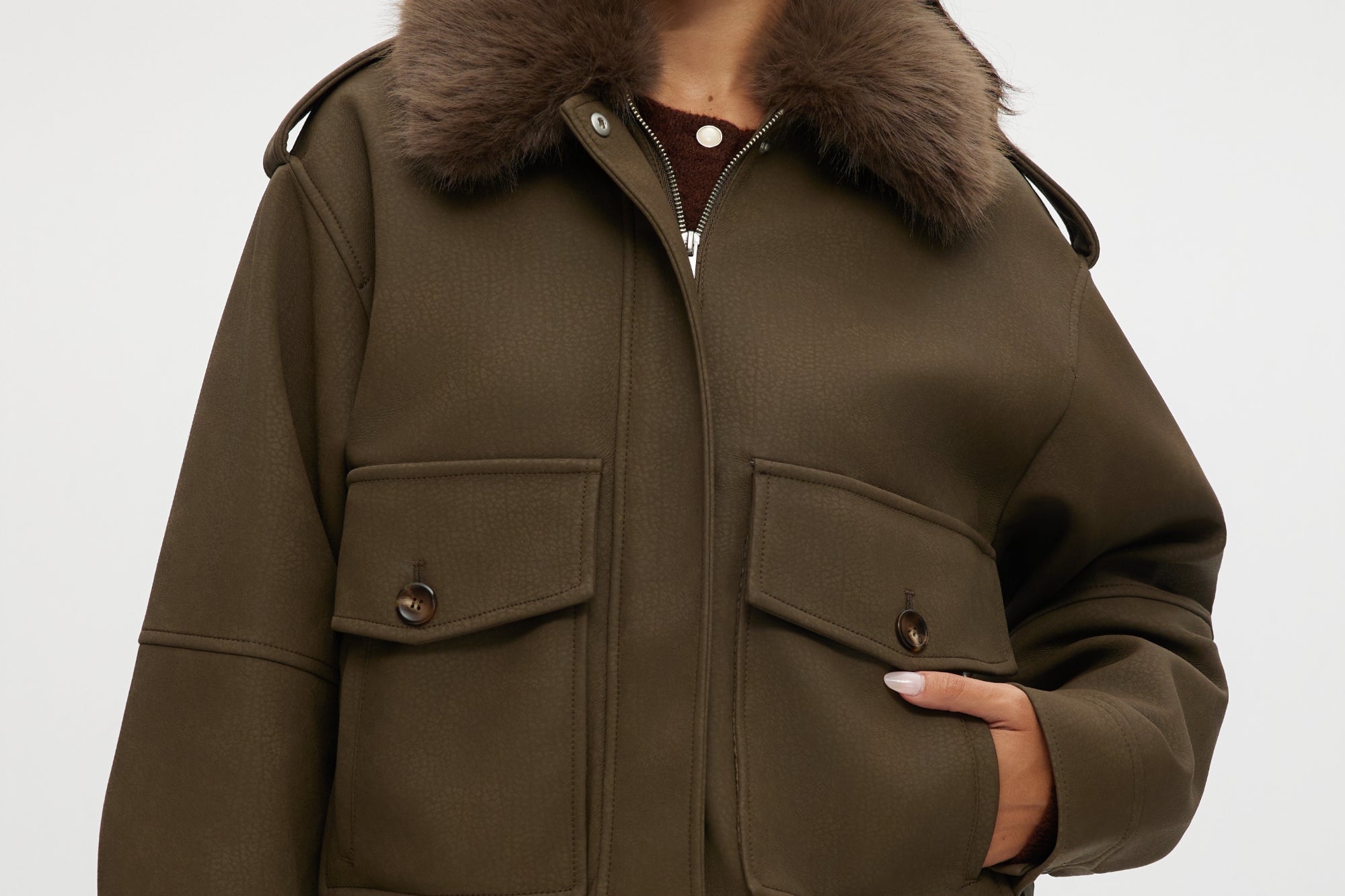 Olive coated jacket with removable faux fur collar, flap pockets, and ribbed hems.