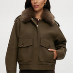Olive coated jacket with removable faux fur collar, flap pockets, and ribbed hems.