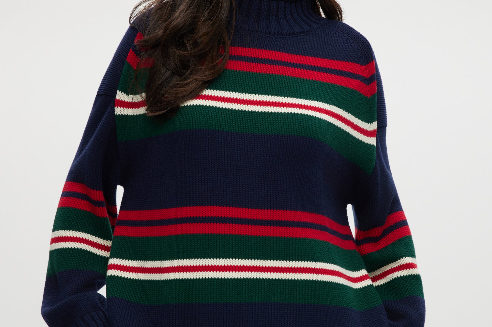 Navy sweater with red, green, and white stripes, high neck, long sleeves.