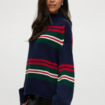 Navy Stripe Rolled Neck Sweater featuring red, green, and white stripes with a high neck and long sleeves by Hilary Radley.