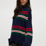Navy Stripe Rolled Neck Sweater featuring red, green, and white stripes with a high neck and long sleeves by Hilary Radley.